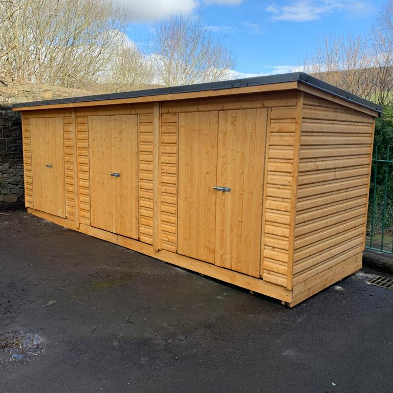 3 storages sheds linked with metal sheets on the roof. Delivered and installed into a school. South Wales.