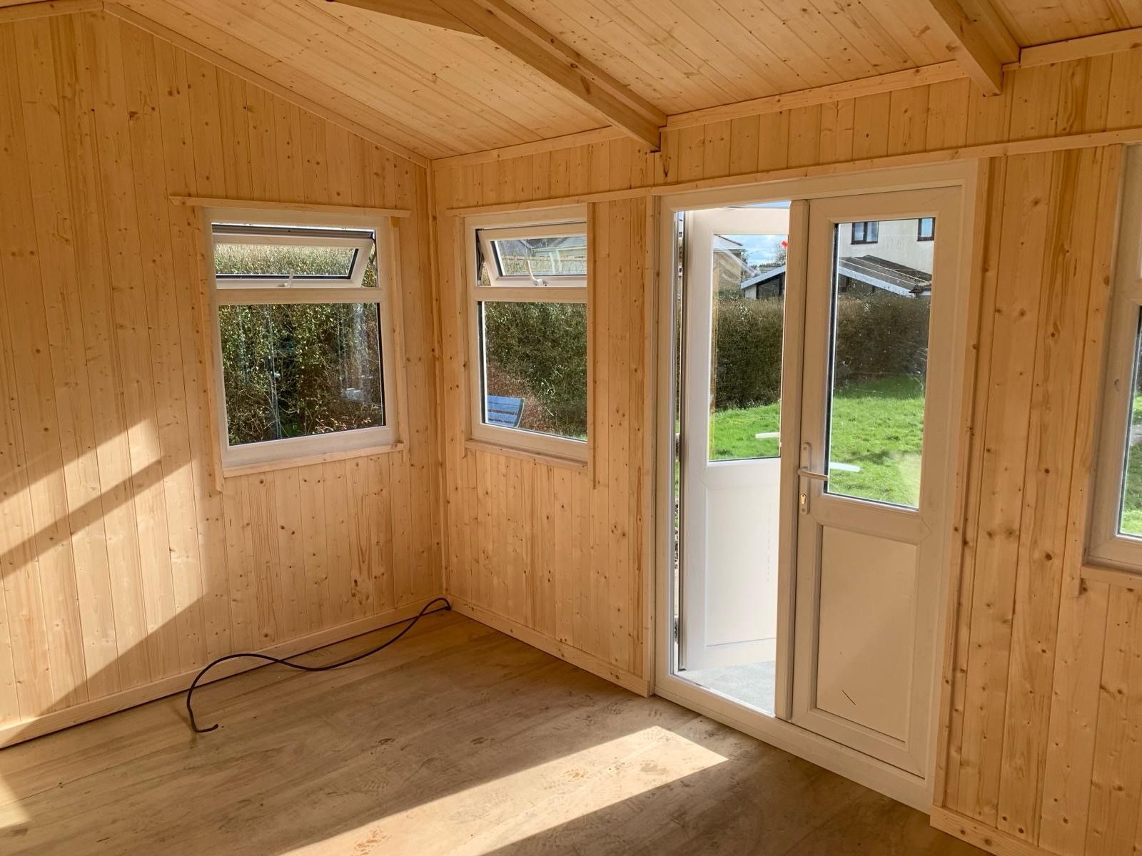 14' x 10' Reverse Apex fully lined and insulated with white pvc windows and doors. Metal box profile roof sheets. Pictured from inside.