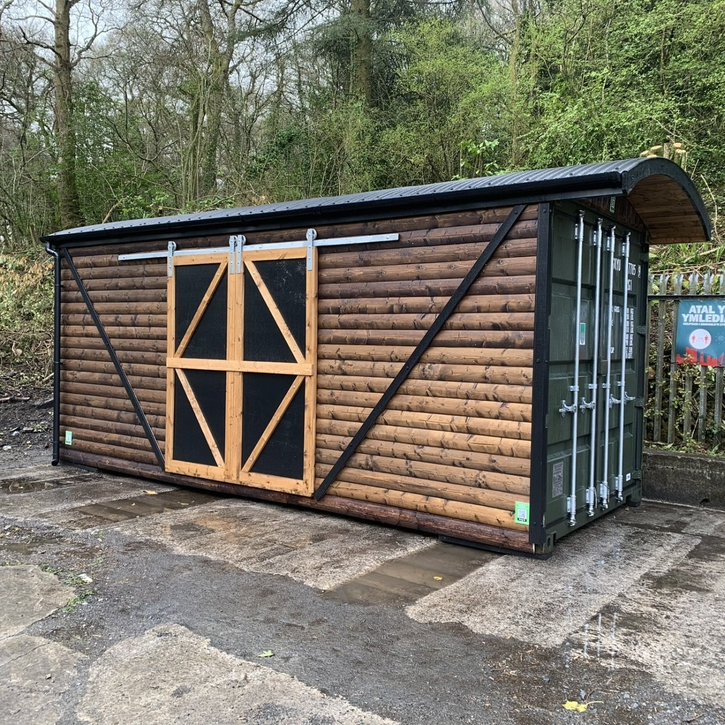 20' x 8' Metal Storage container made to look like an old railway carriage. Effects of the sliding doors on the side and a curved roof with overhang where the container opens.