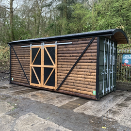 20' x 8' Metal Storage container made to look like an old railway carriage. Effects of the sliding doors on the side and a curved roof with overhang where the container opens.