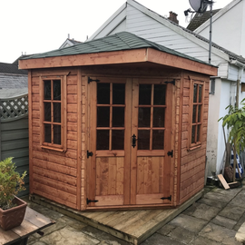 7' x 7' Corner Summerhouse painted in Oil based preservative. Mortice lock and key. Shingles on the roof choice of 3 colours.