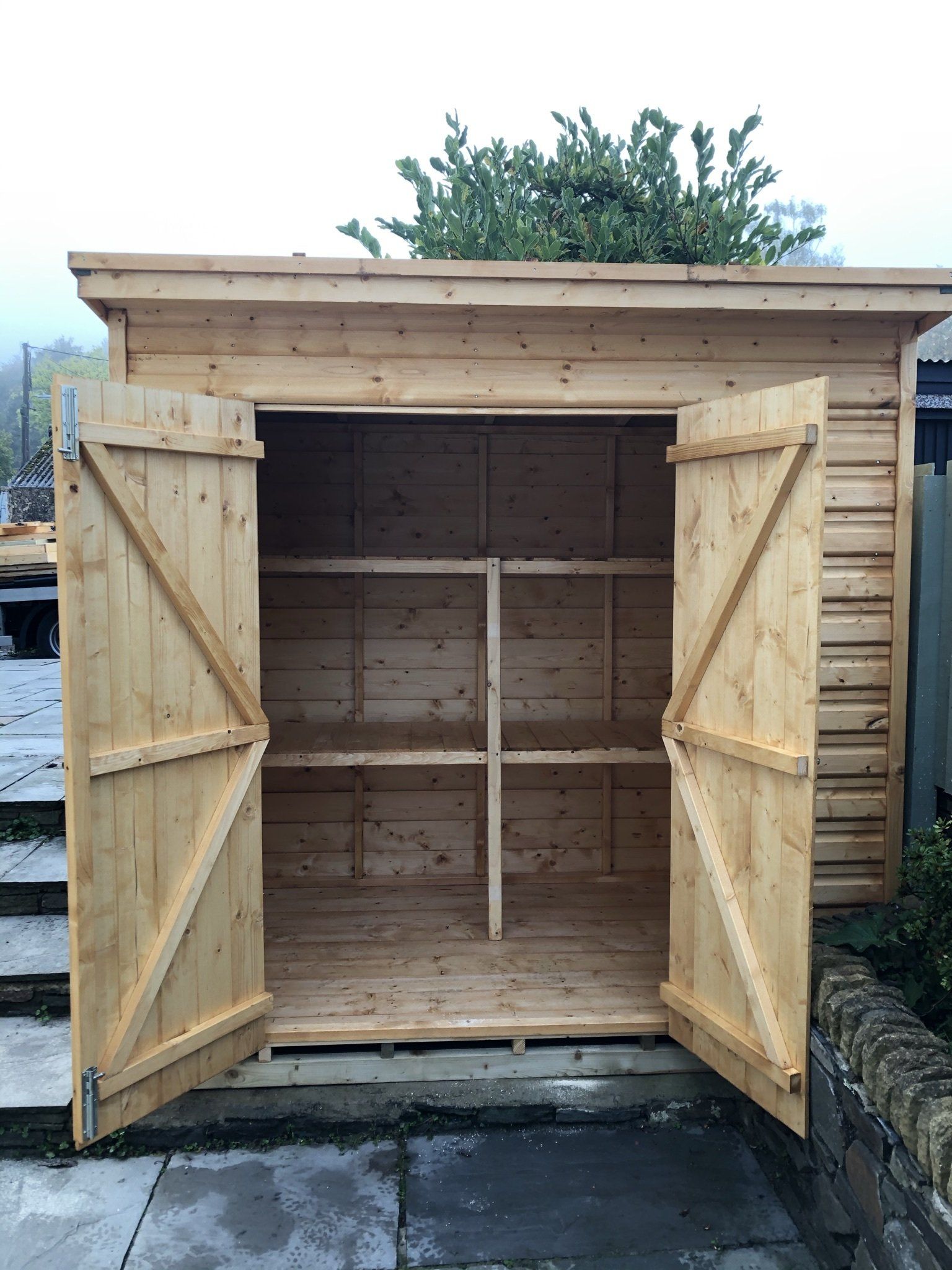 Shed height storage with double doors open to see the shelving set up.