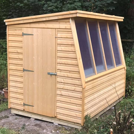 8' x 6' Potting shed with 4 panes of perspex on the 8' end and a bench under the window. Door set in on the 6' side. Roof at an angle to allow for water to run off into a water system.
