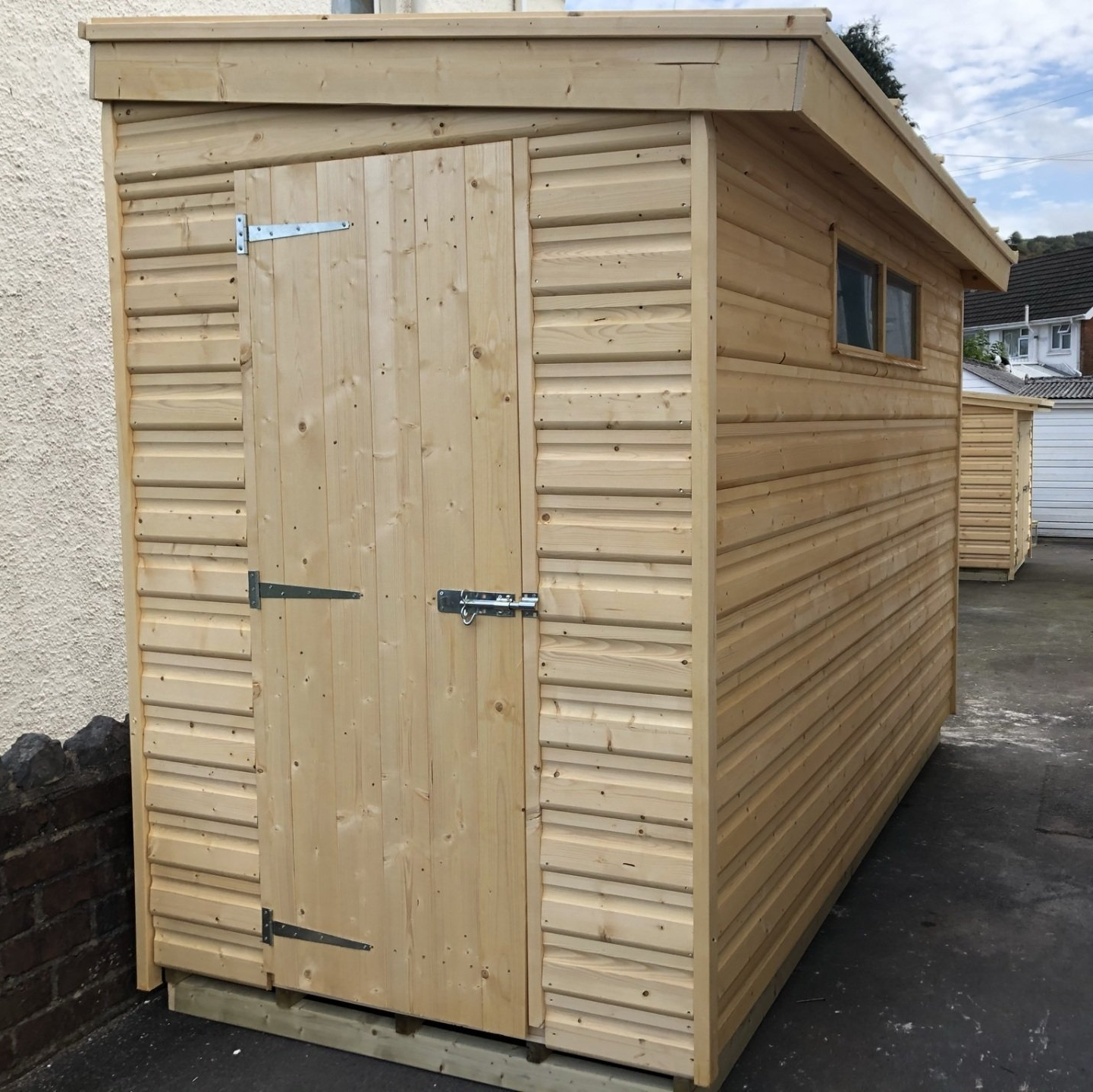 Pent shed with door on the short end and security windows on the right hand side which is suited if you don't need that much light.