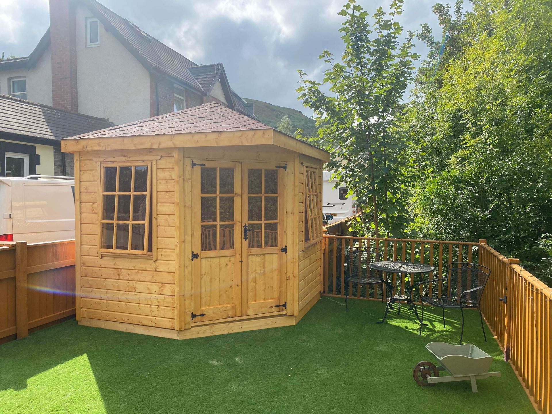 9' x 9' Corner summerhouse with red shingles and opening 9 pane windows. Lined and insulated.