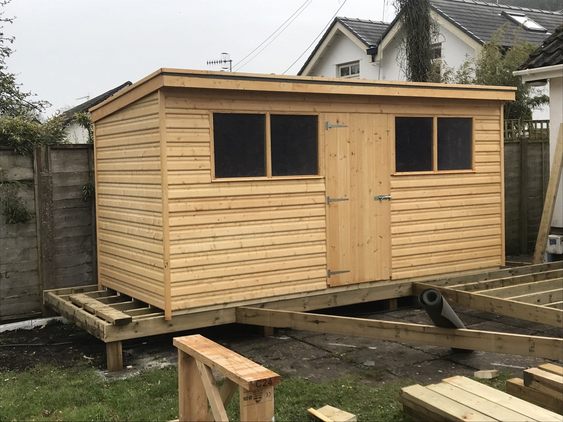 14' x 6' pent shed with single door in the middle and two 4' x 2' windows either side of the door.
