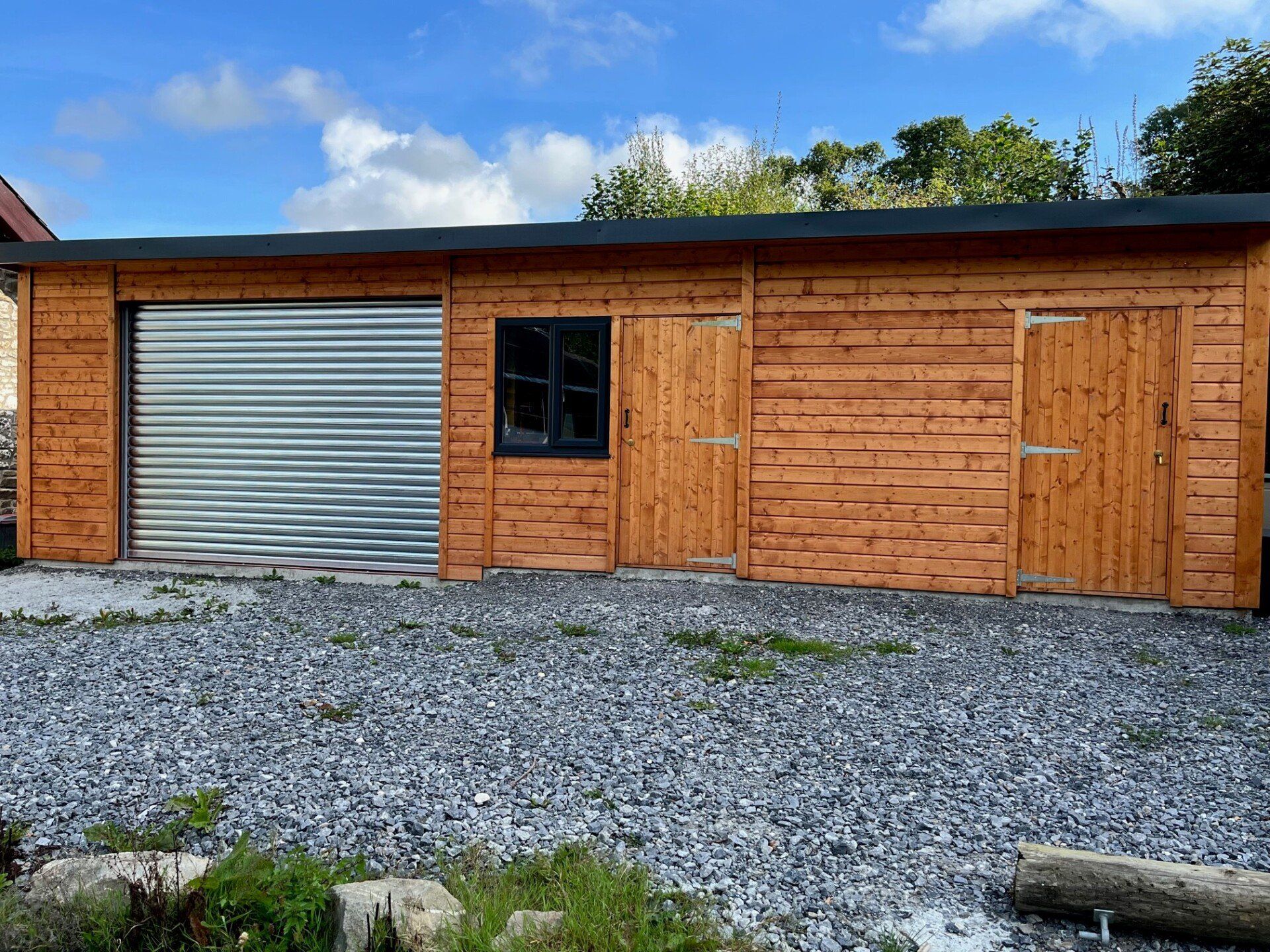 A multi-use building with roller shutters, mortice lock and key for both wooden doors. Anthracite PVC windows with metal box profile roof sheets to match. 37' x 12'