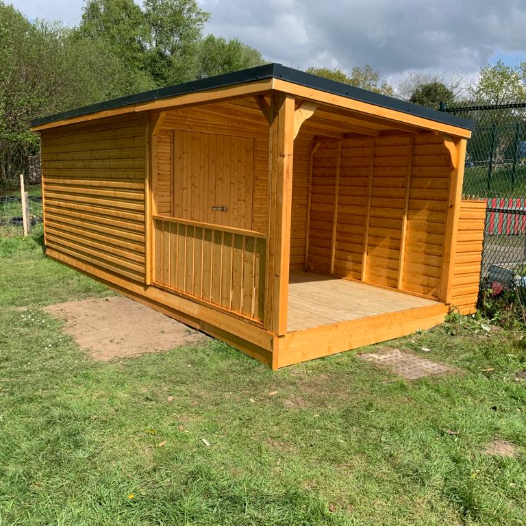 Multiuse storage shed with double doors out onto a deck that can be used as a stage. 