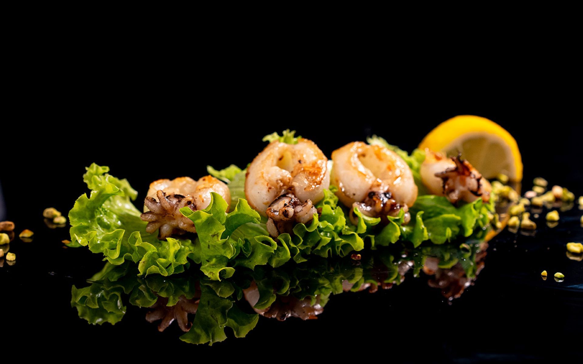 Anelli di calamaro grigliati su lattuga e limone