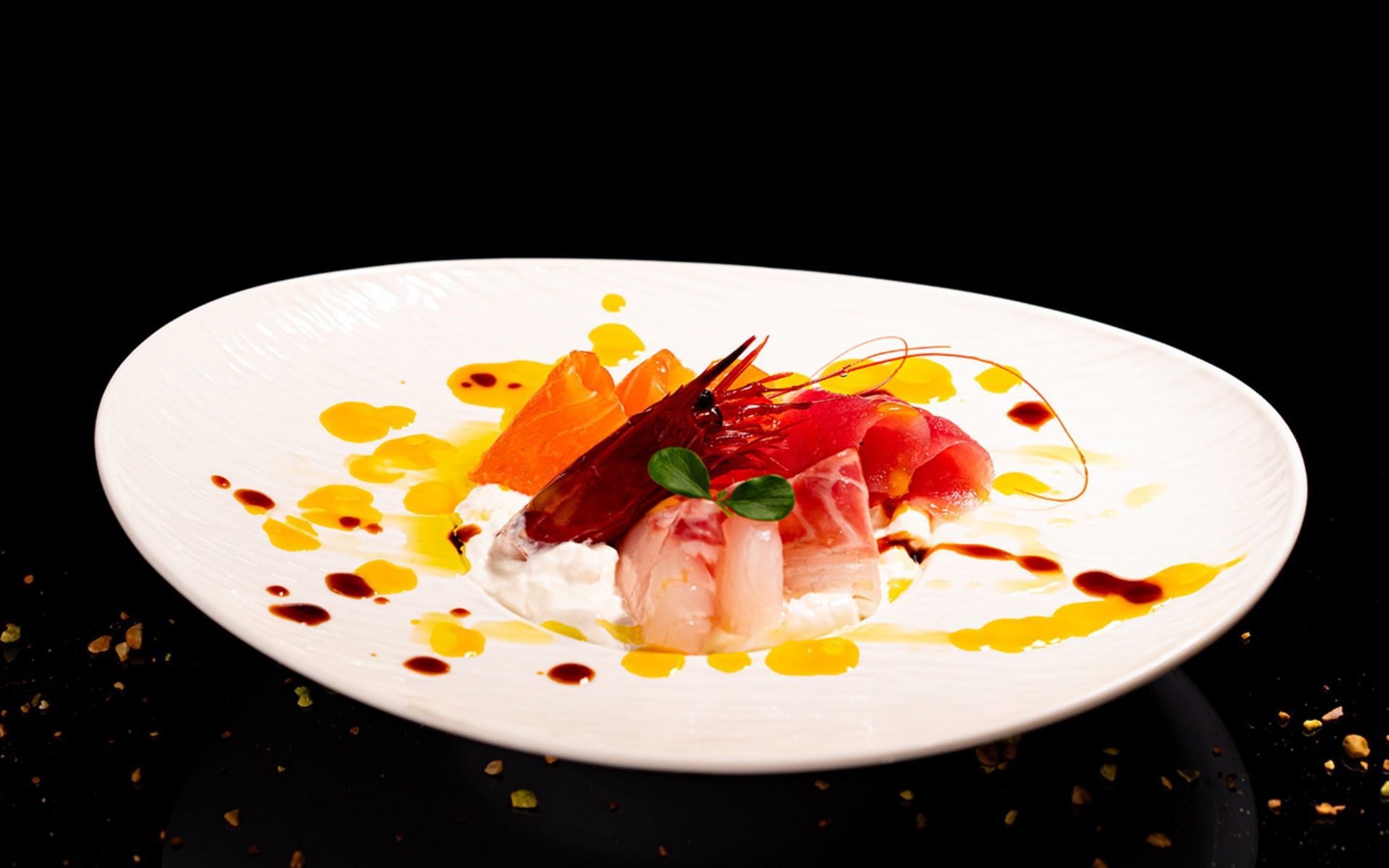 Sushi su un piatto bianco, guarnito con salsa all'arancia