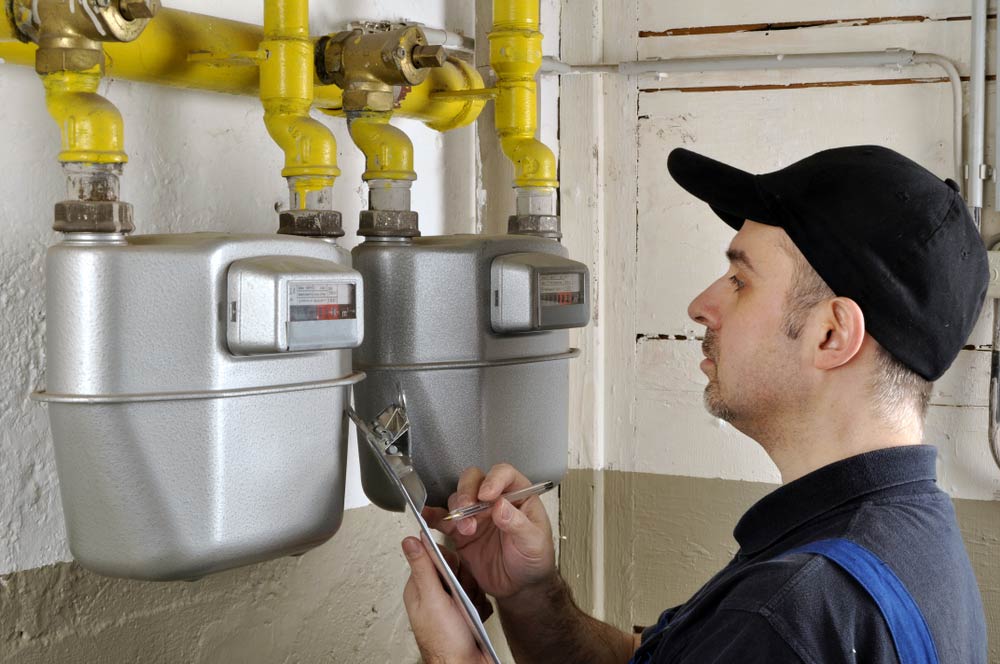 Gas Fitter Inspecting Heating System in Home