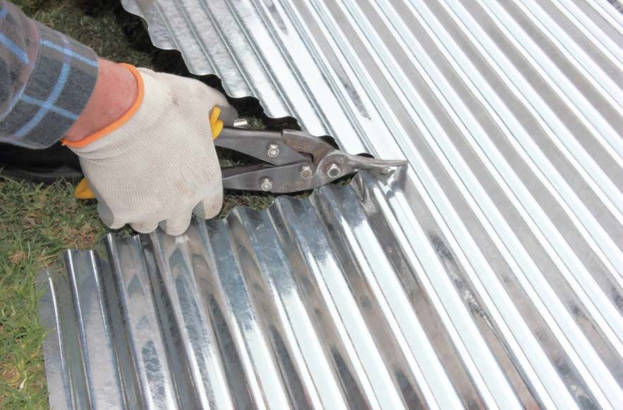 Man Cutting A Metal Roof For Repairs