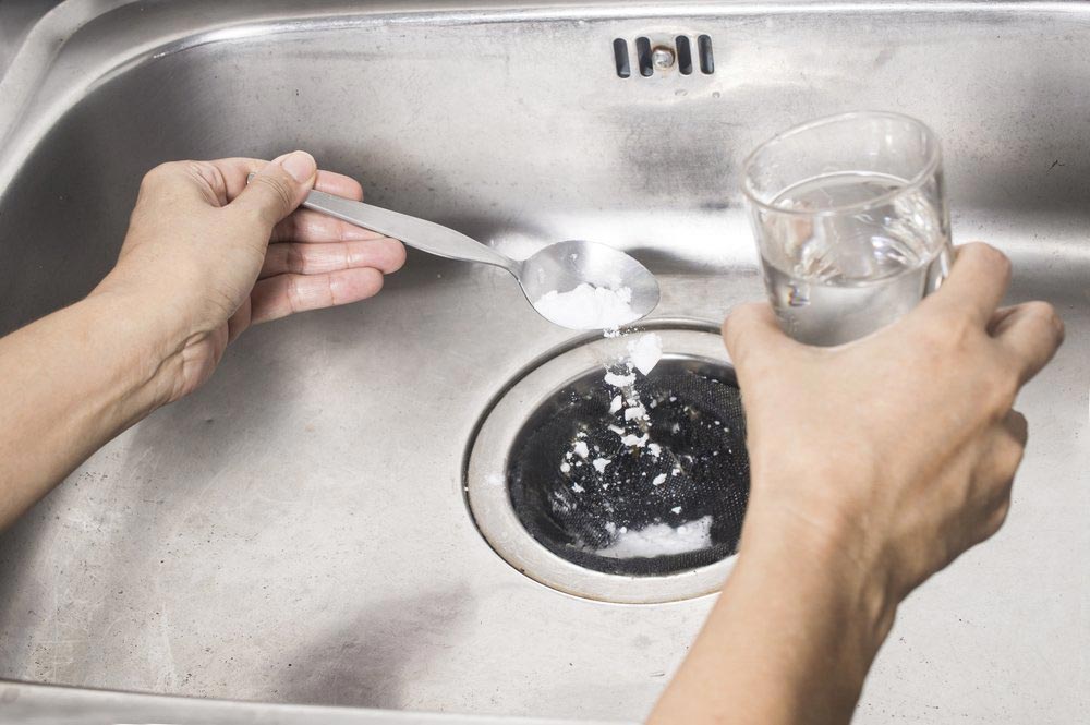 Pouring Baking Soda And Vinegar To Blocked Drain