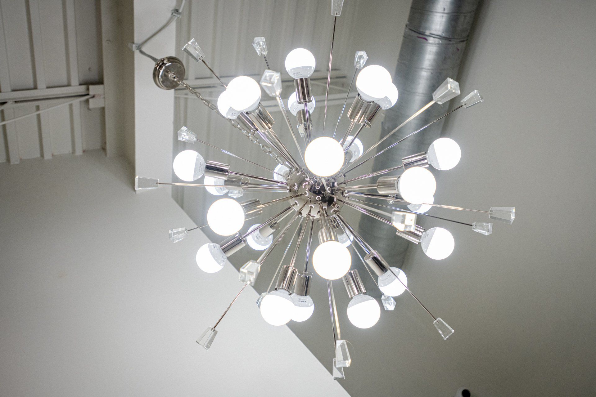 Brocatos Collective chandelier with a lot of lights hanging from the ceiling.