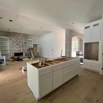 A kitchen under construction with a large island in the middle of the room.