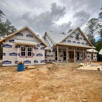 A house is being built in the middle of a dirt field.