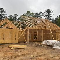 A house is being built in the middle of a dirt field.
