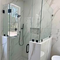 A bathroom with a walk in shower and a toilet.