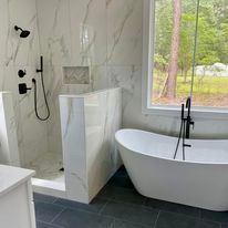 A bathroom with a tub , shower and window.