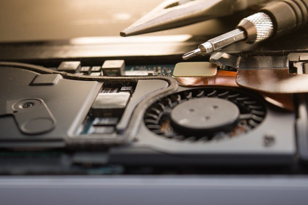 A Close Up Of A Laptop With A Fan And A Soldering Iron — Black Label I.T. in Garbutt, QLD