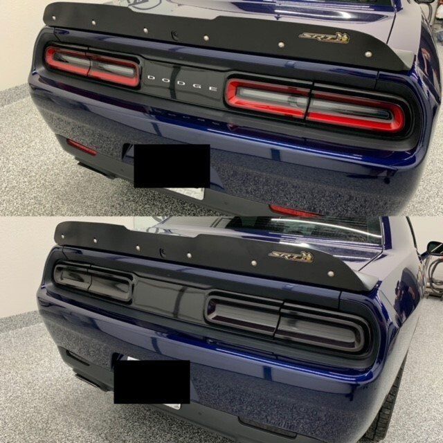 The rear end of a blue dodge challenger is shown