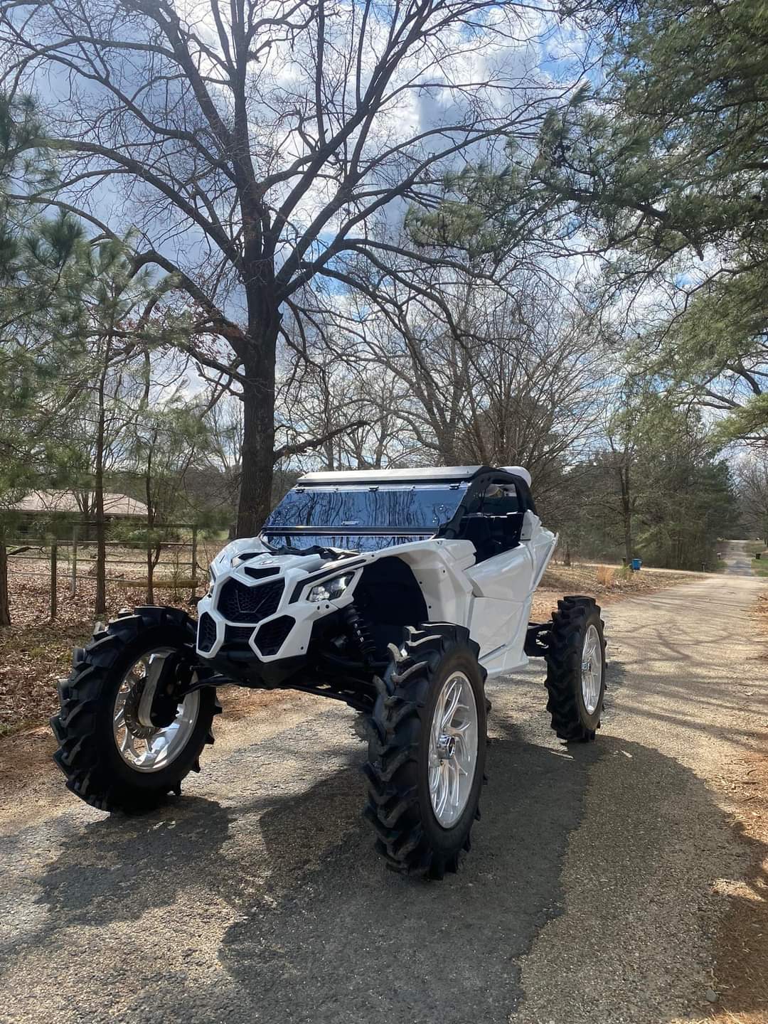 A white atv is parked on the side of a road.