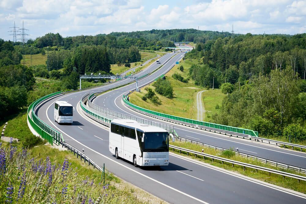 White Buses Driving On The Highway — Local Bus Hire in Evans Head, NSW