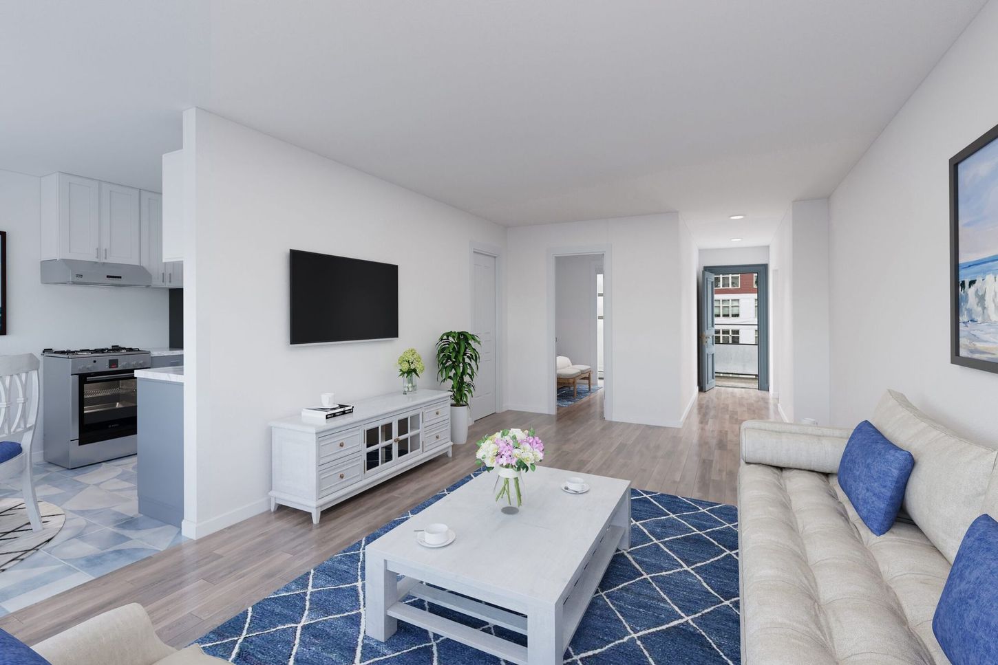 Living room with blue rug, white sofa, TV, and open kitchen.