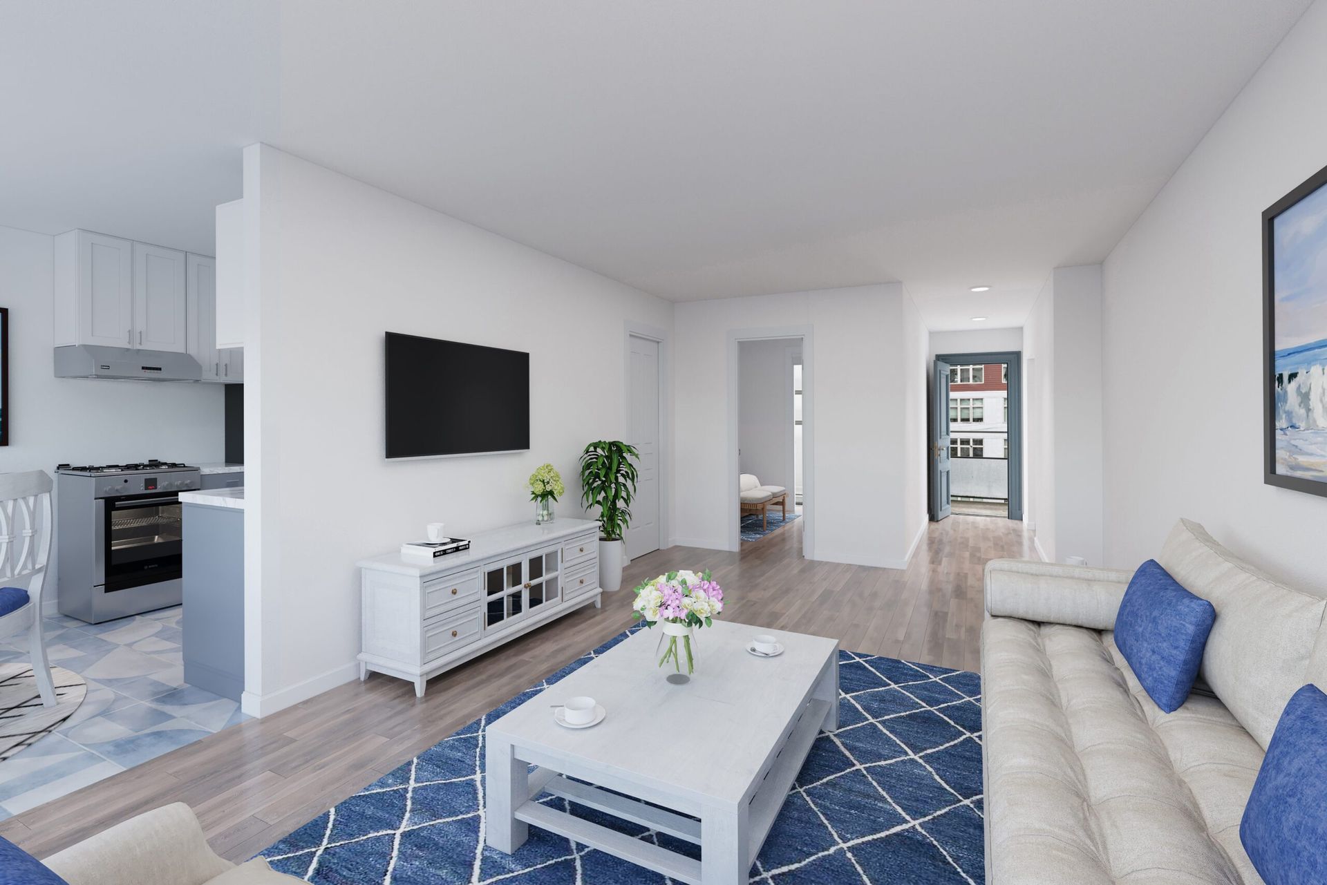 Living room with blue rug, white sofa, TV, and open kitchen.