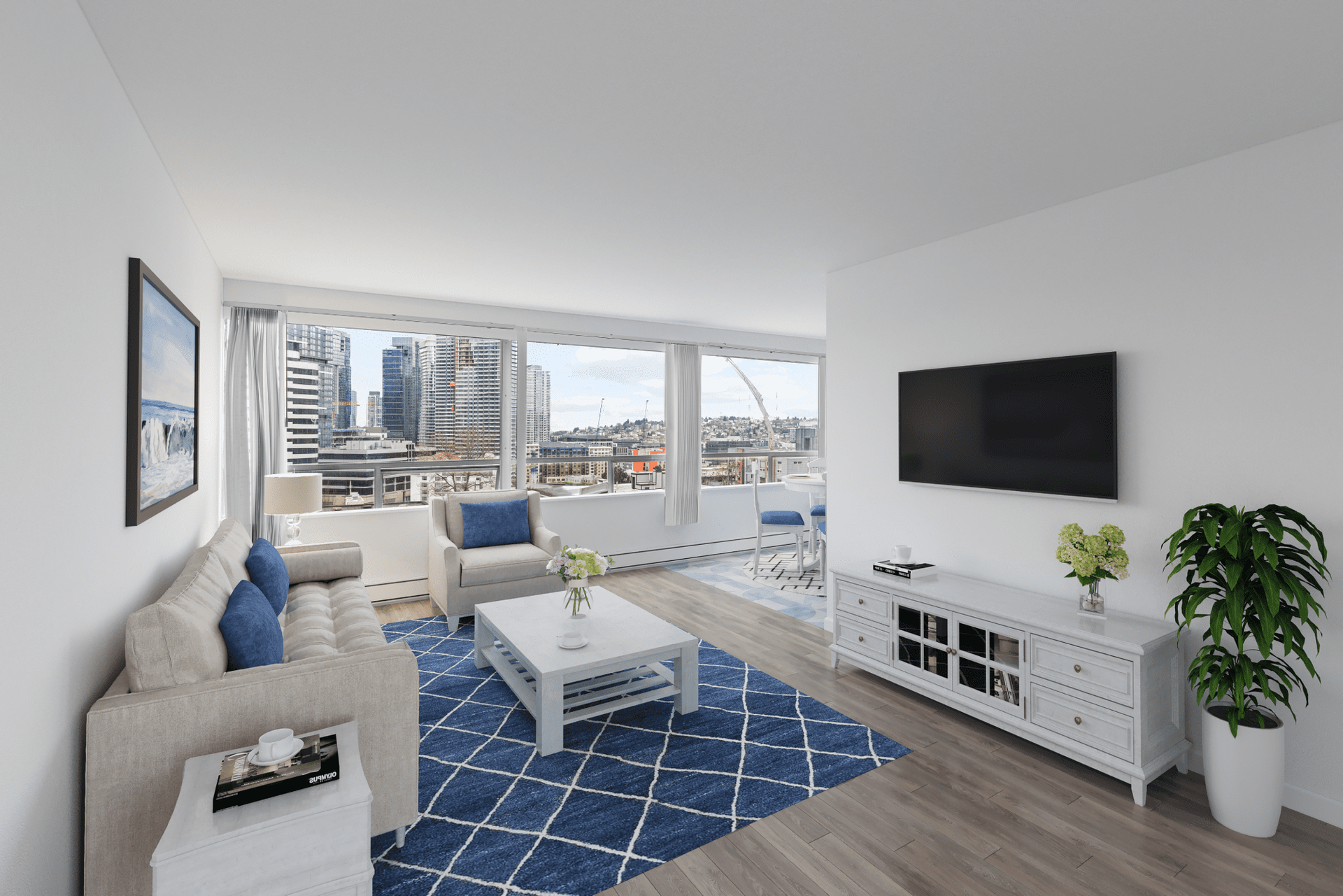 Living room with city view, blue rug, white furniture, TV on wall, and a plant.