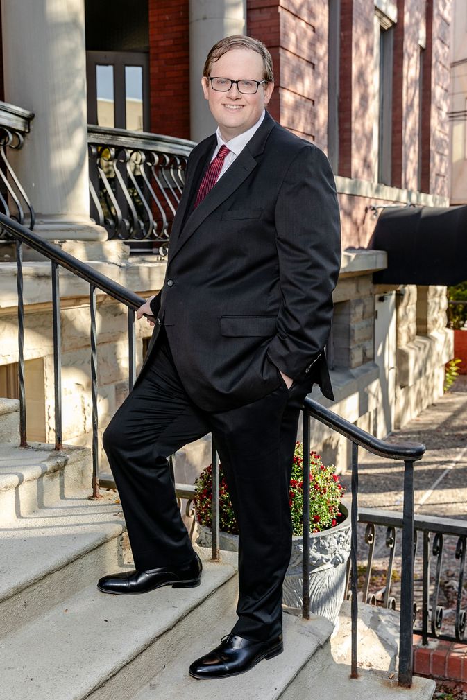 A man in a suit and tie is standing on a set of stairs .