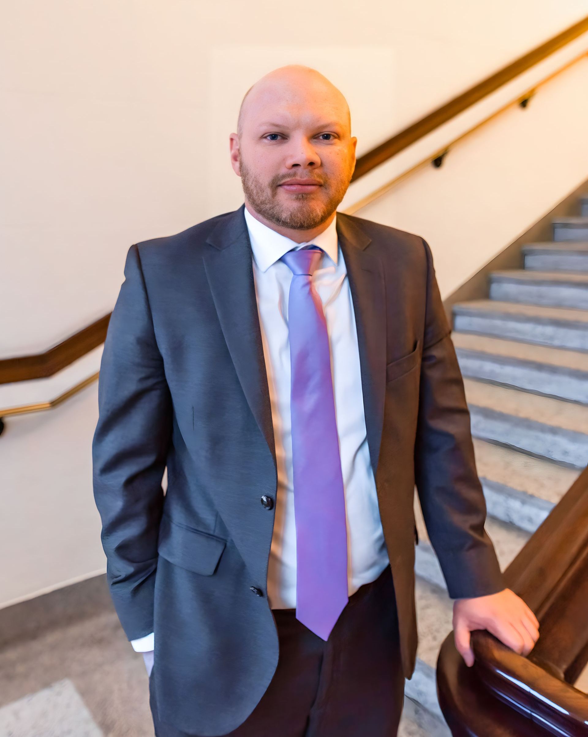 A man in a suit and tie is standing on a set of stairs.