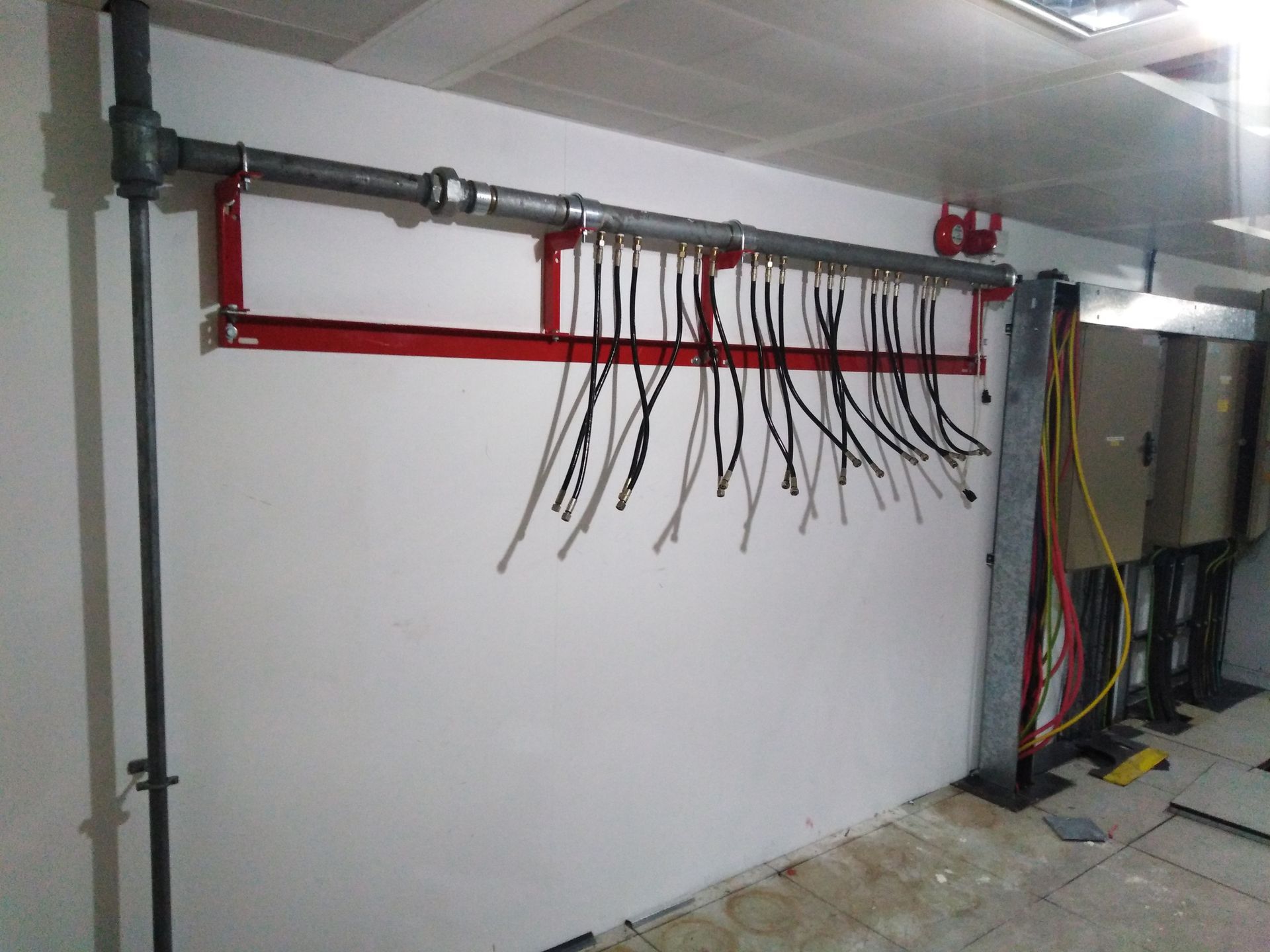 A bunch of wires are hanging on a wall in a room.