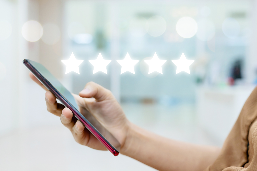 A person is holding a cell phone with five stars on it.