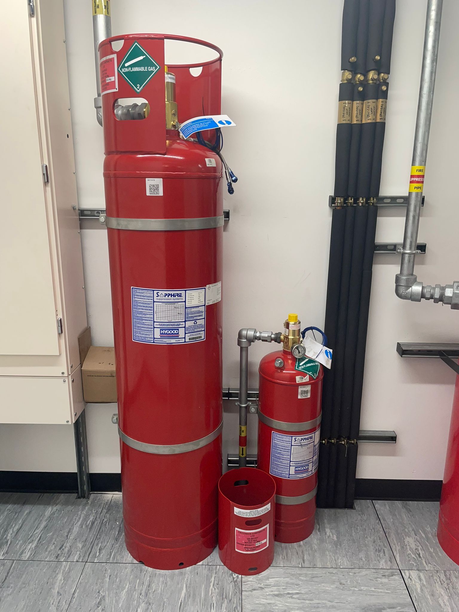 A group of red fire extinguishers are stacked on top of each other in a room.