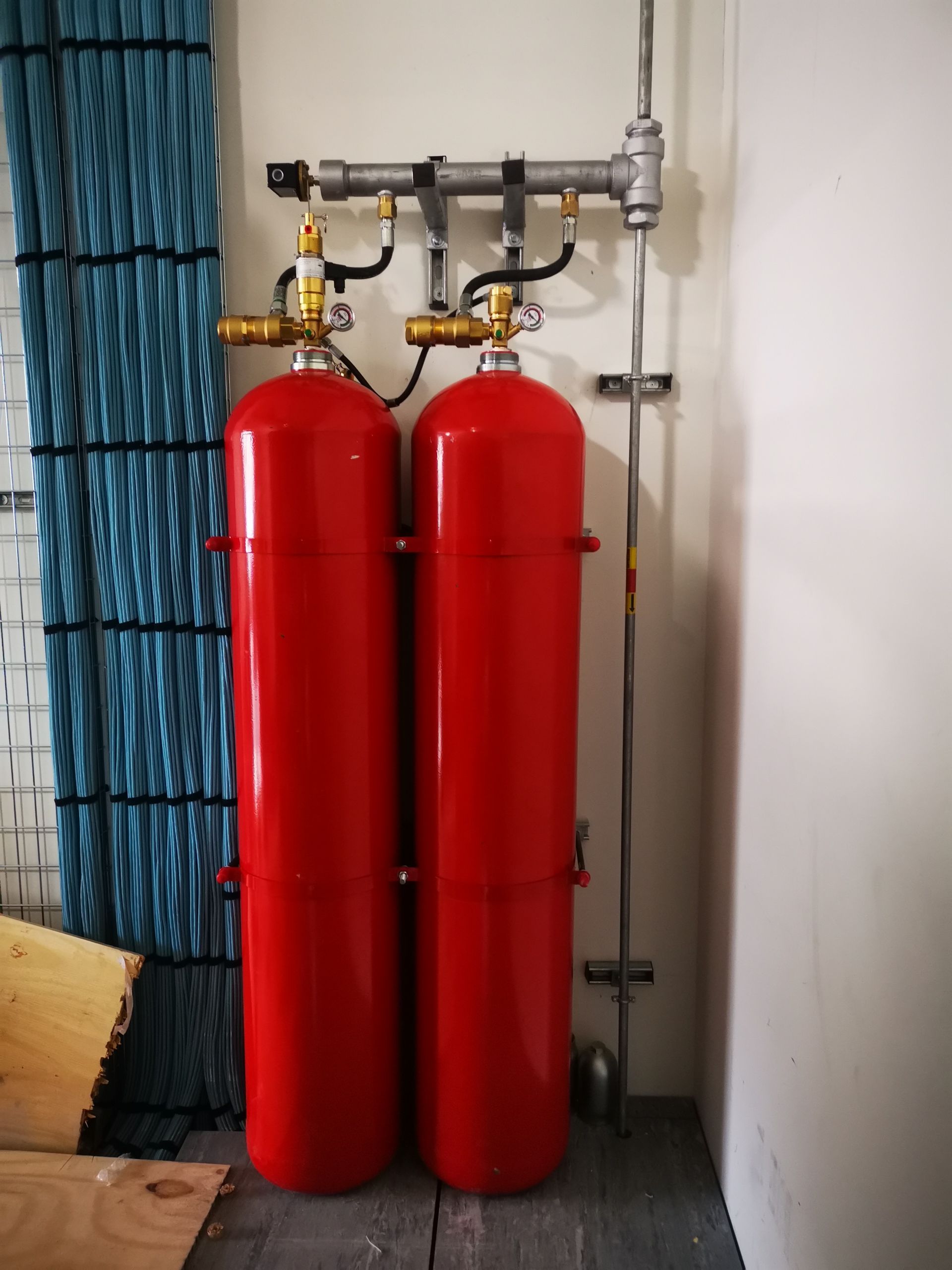 Two red fire extinguishers are sitting next to each other in a room