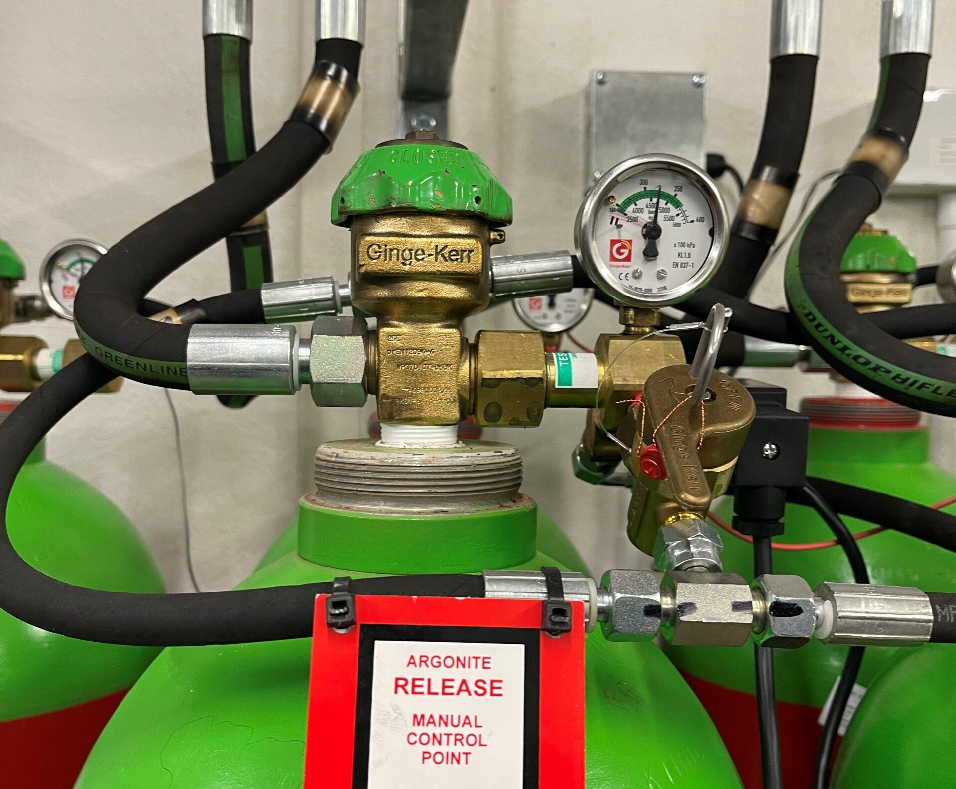 A close up of a gas cylinder with a sign that says ' aircraft release manual control point '