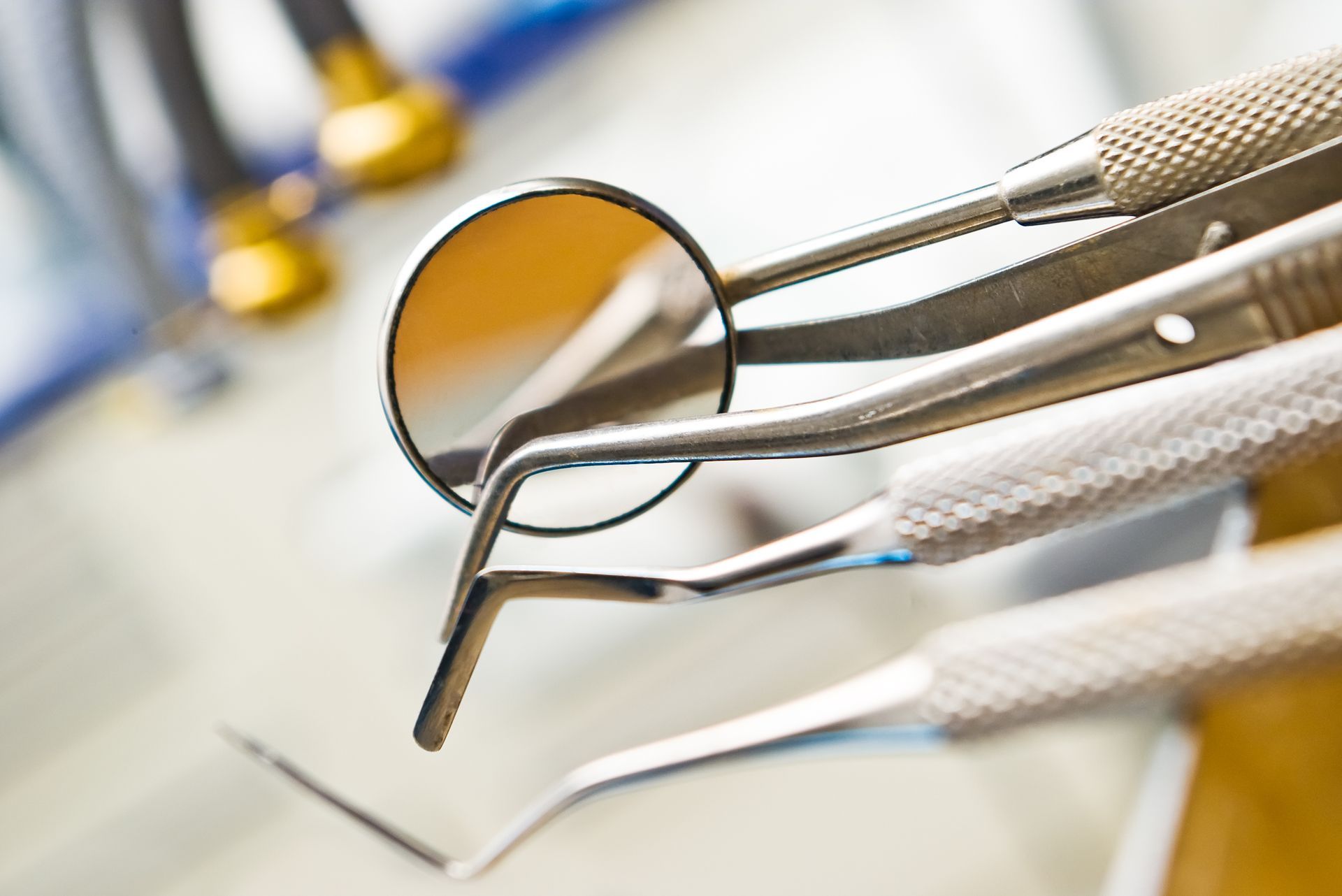 Dental tools: mirror, explorer, and other instruments arranged on a surface, likely at a dentist's office.