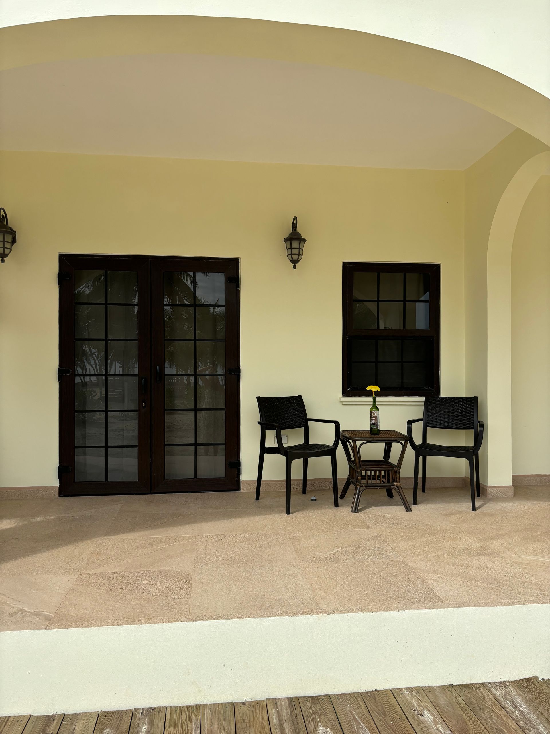 A porch with chairs a table and a window