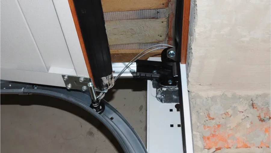Close-up of a wheelchair wheel and metal frame beside a doorway and wall damage
