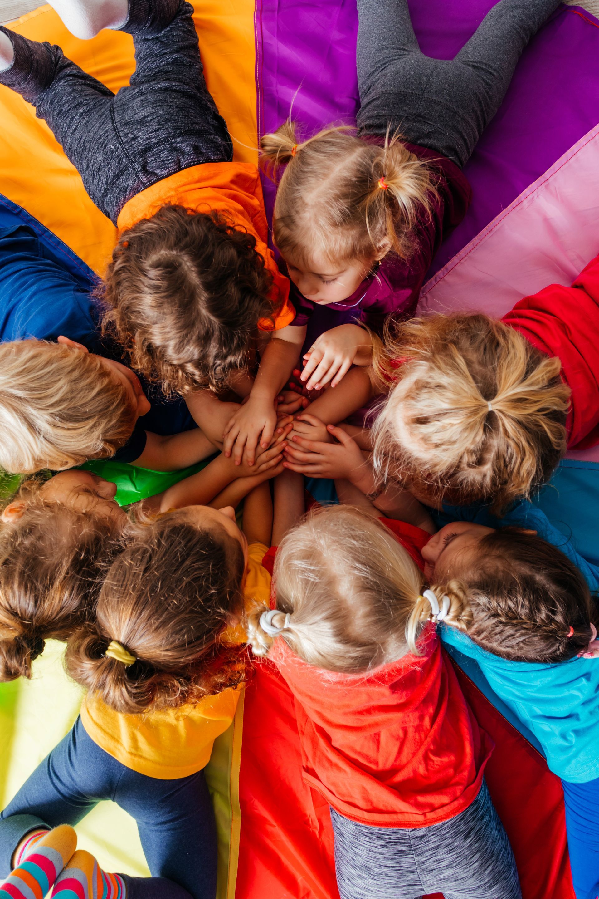 Cheerful children playing team building games on a floor.