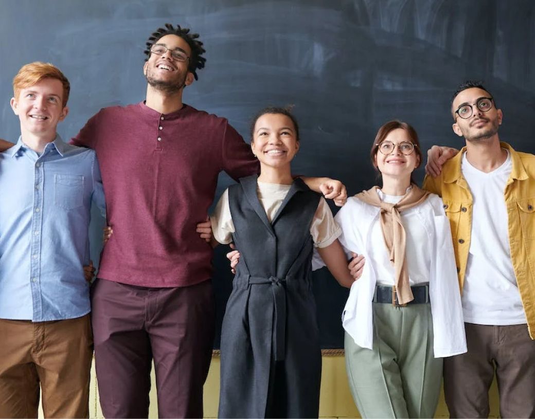 A group of people are posing for a picture in front of a blackboard.