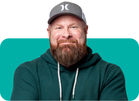 A man with a beard is wearing a hat and a green hoodie.