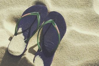 par de sandalias na areia