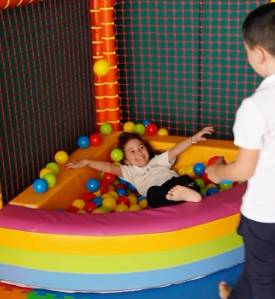 Piatto bianco con pesce avvolto in foglie verdi, irrorato con una salsa verde chiaro.