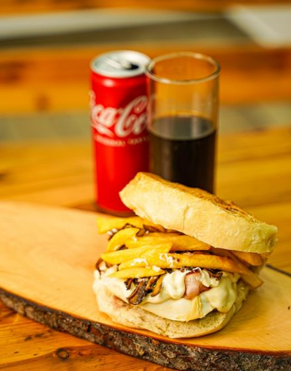 Donna che usa coltello e forchetta per mangiare un piatto verde avvolto in un involucro su un piatto bianco.