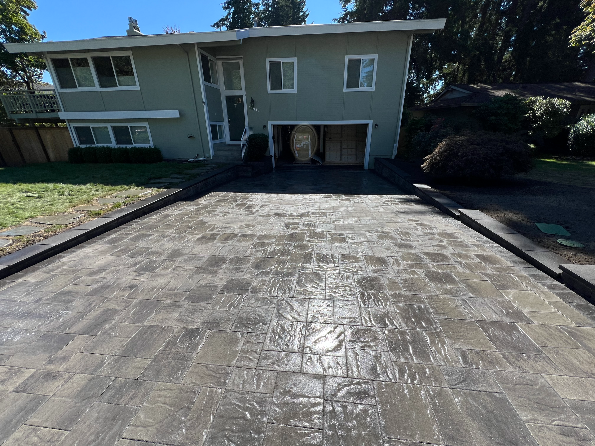 A driveway leading to a large house with a garage.