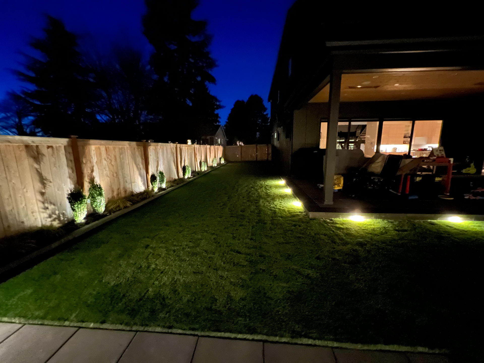 The backyard of a house is lit up at night