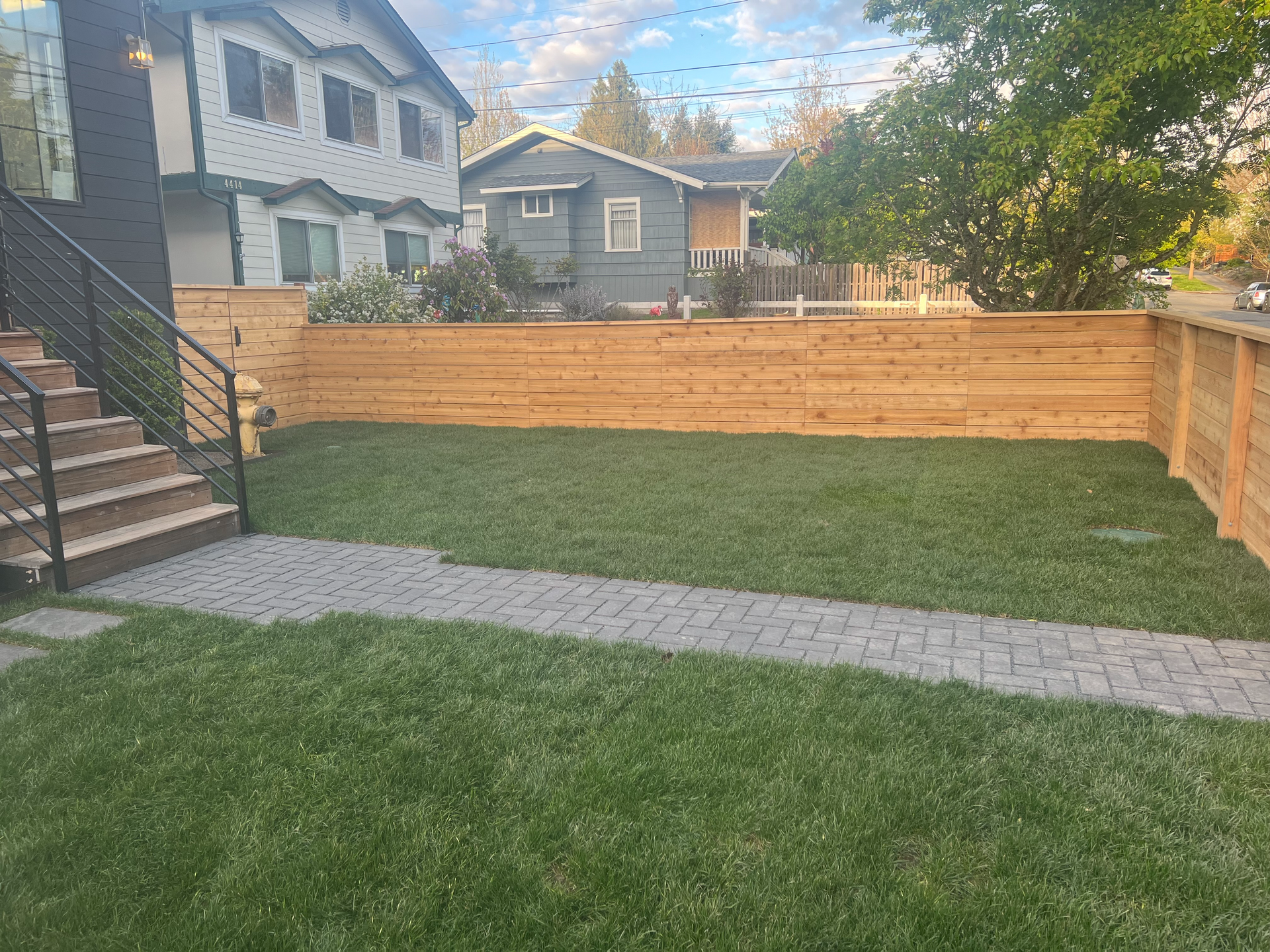 There is a wooden fence in the backyard of a house.
