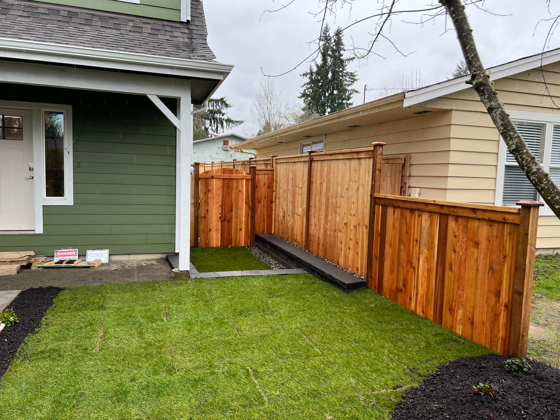 There is a wooden fence in the backyard of a house.